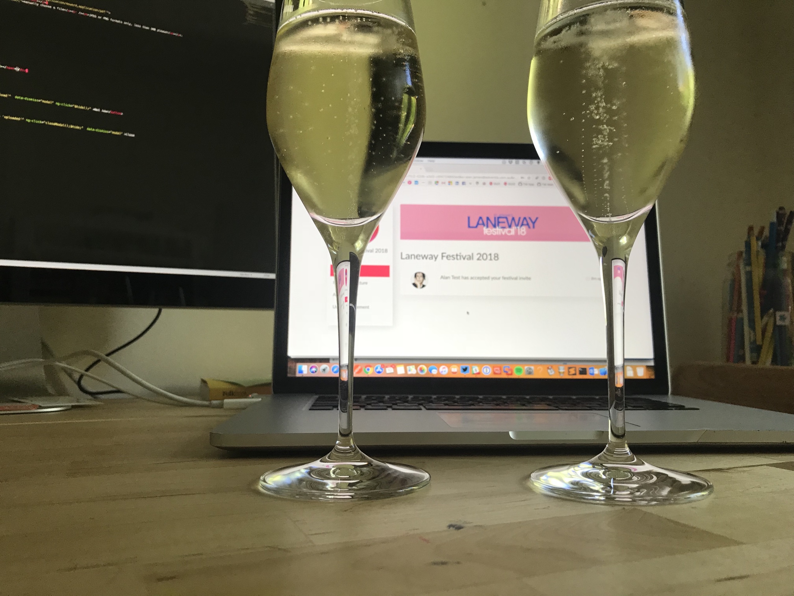 Champagne glasses with the Laneway 2018 invite on screen
